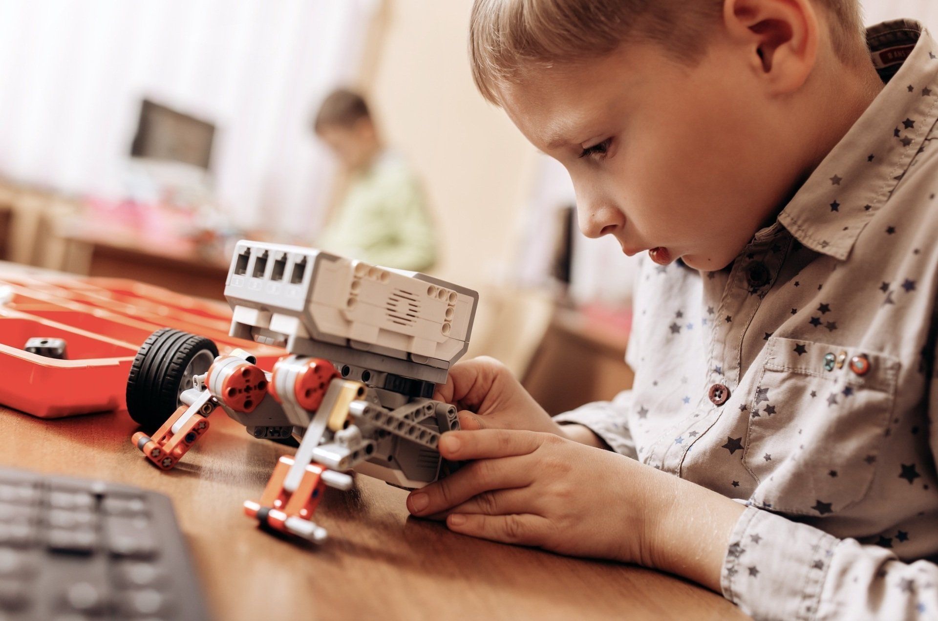 A young boy is playing with a toy robot on a table.