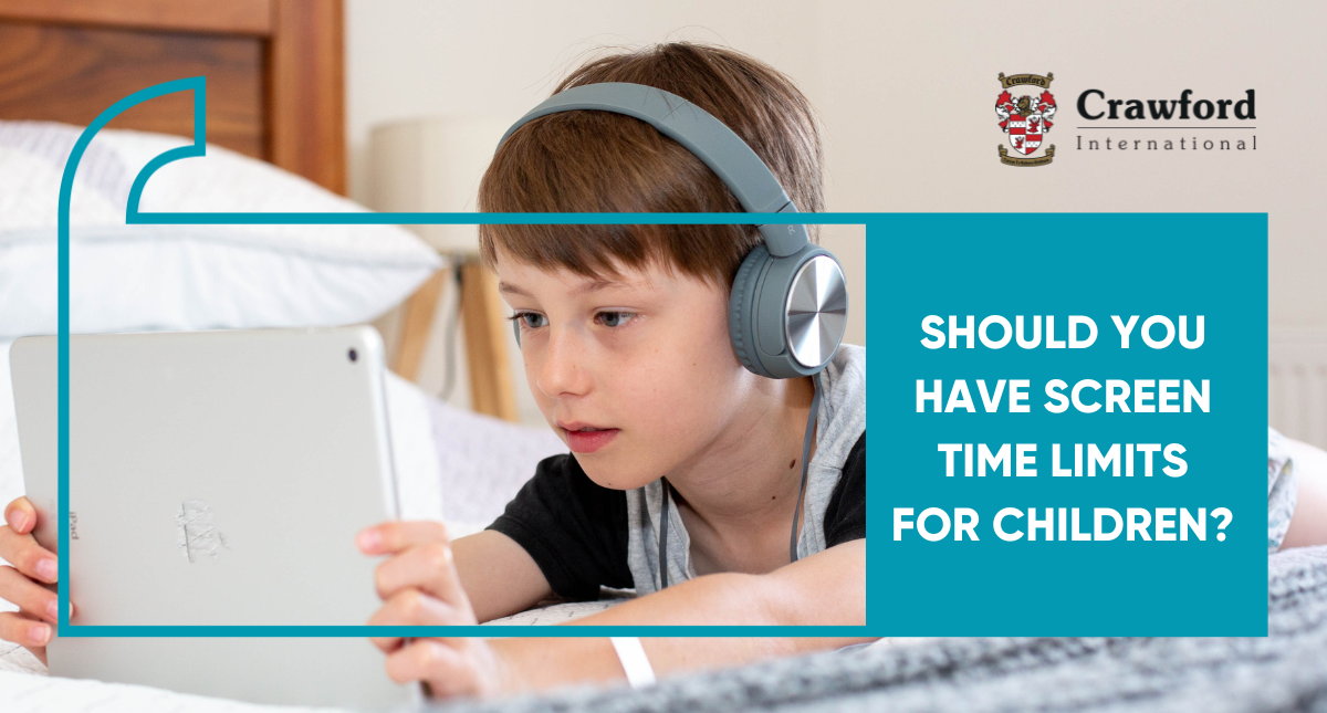 A young boy wearing headphones is using a tablet computer.