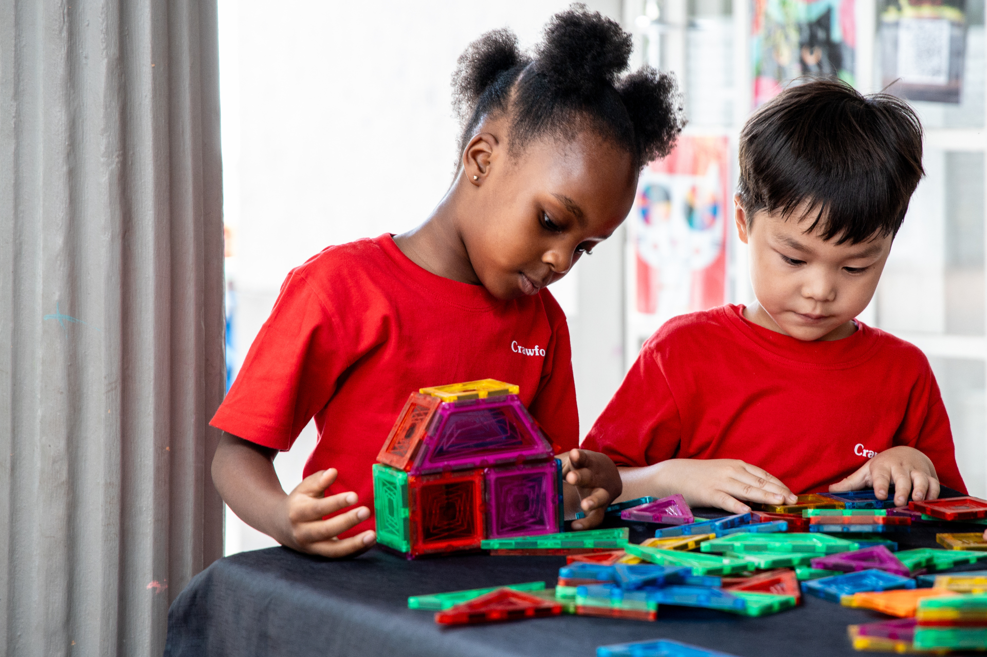 a group of children are playing with toys at a table .