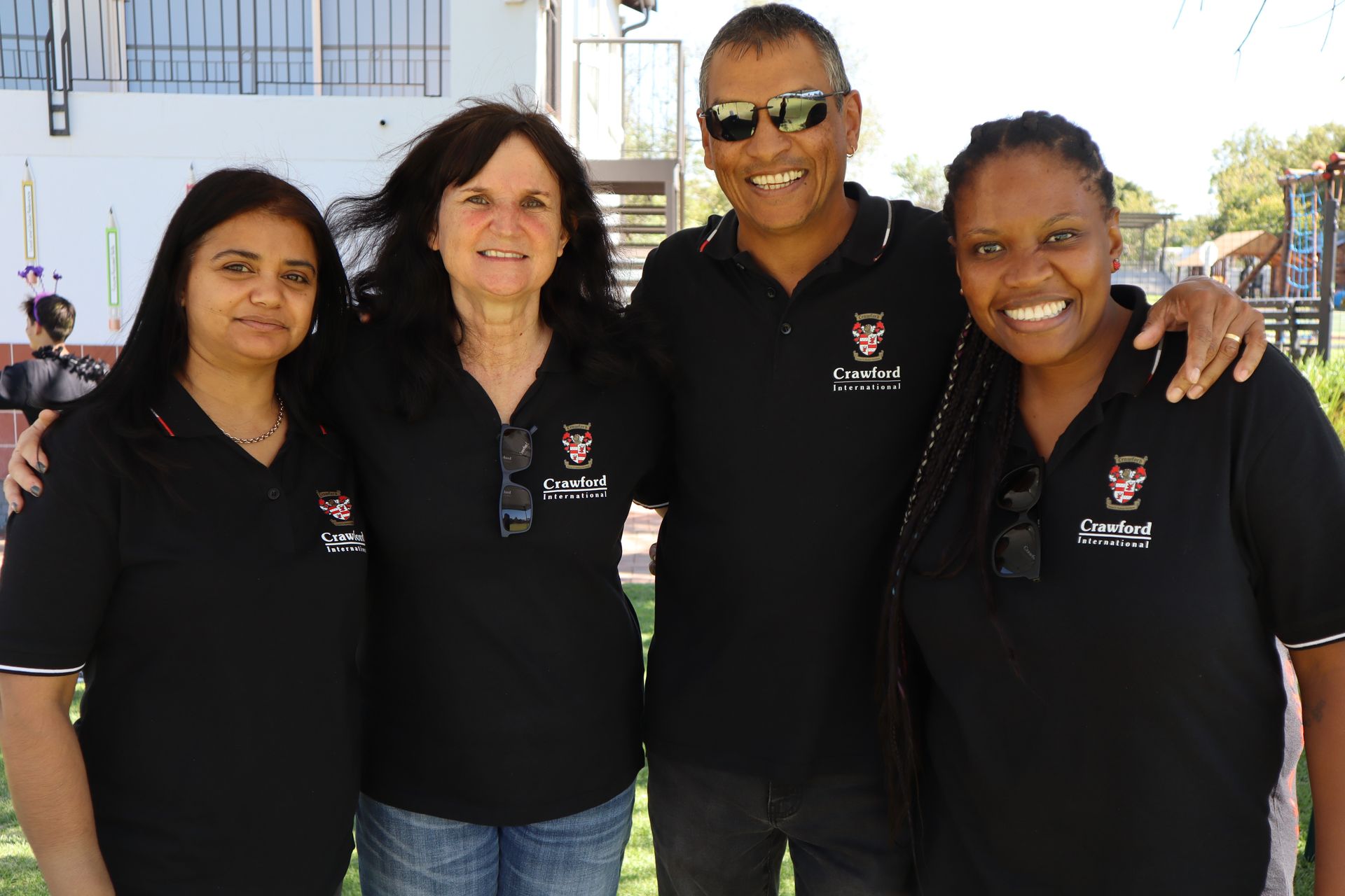 A group of people wearing black polo shirts are posing for a picture.