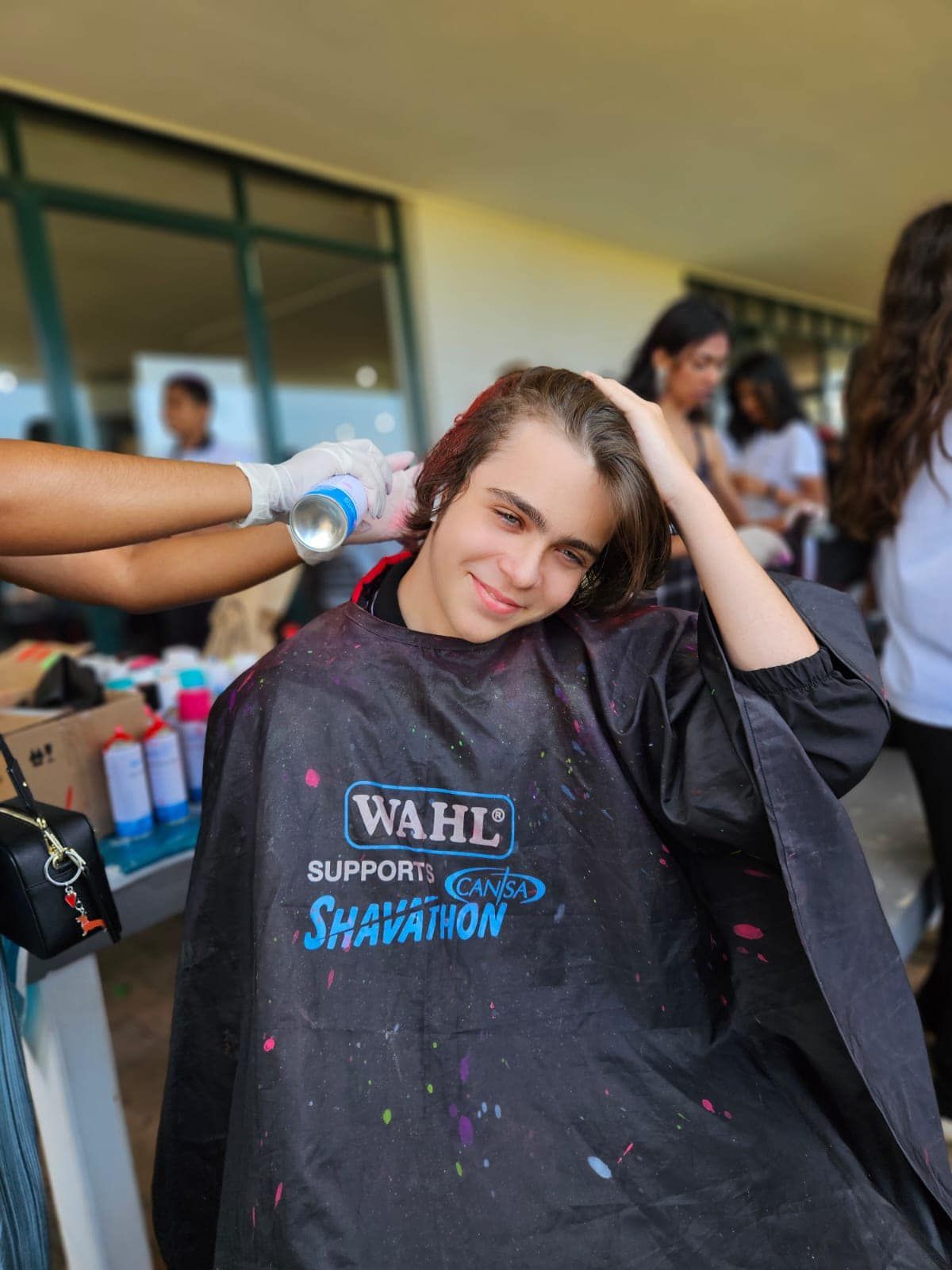 A young man is getting his hair cut by a wahl stylist.