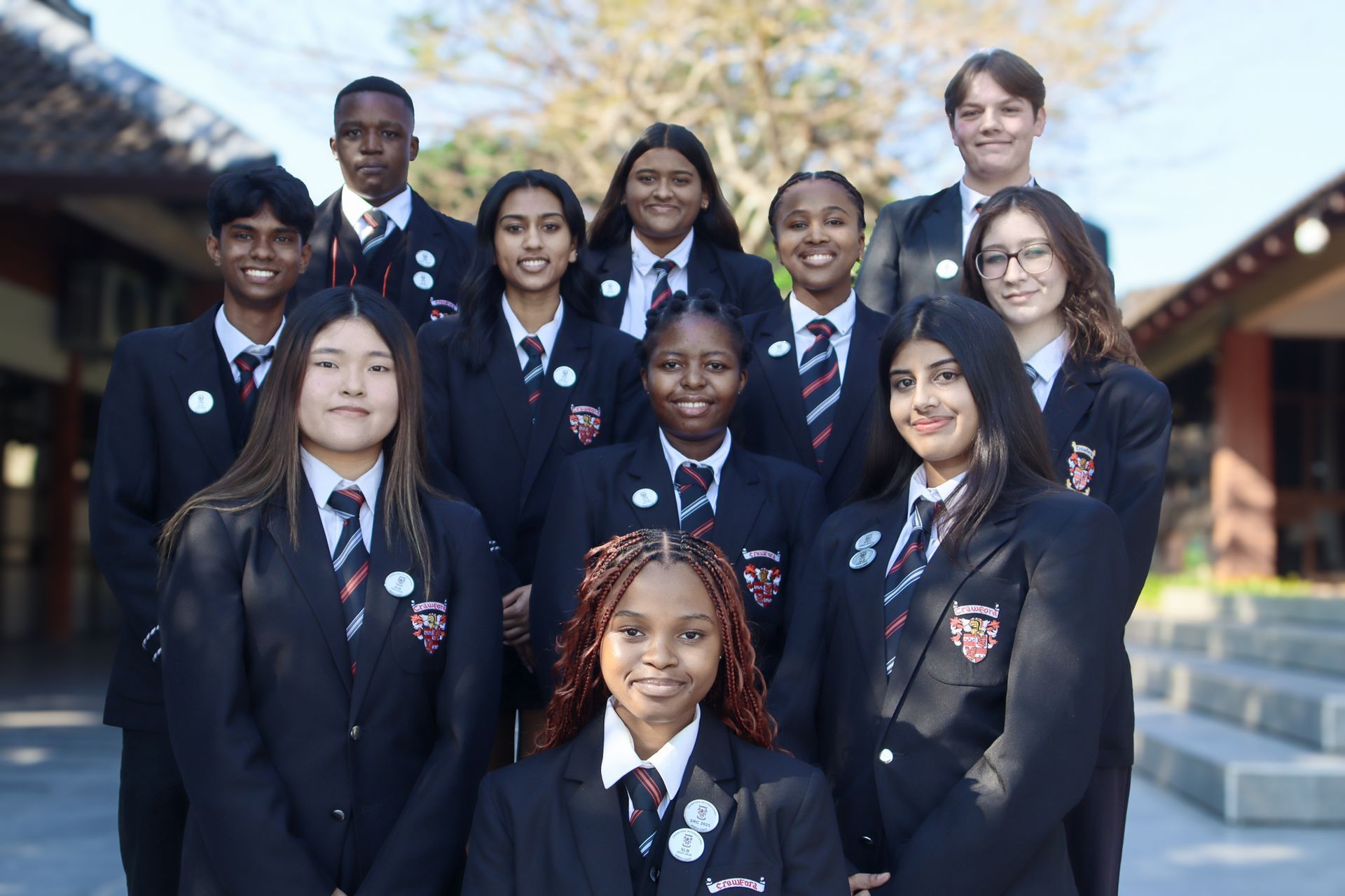 Group of students in school uniforms posing outdoors.