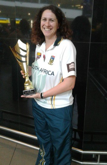 A woman in a south africa shirt is holding a trophy