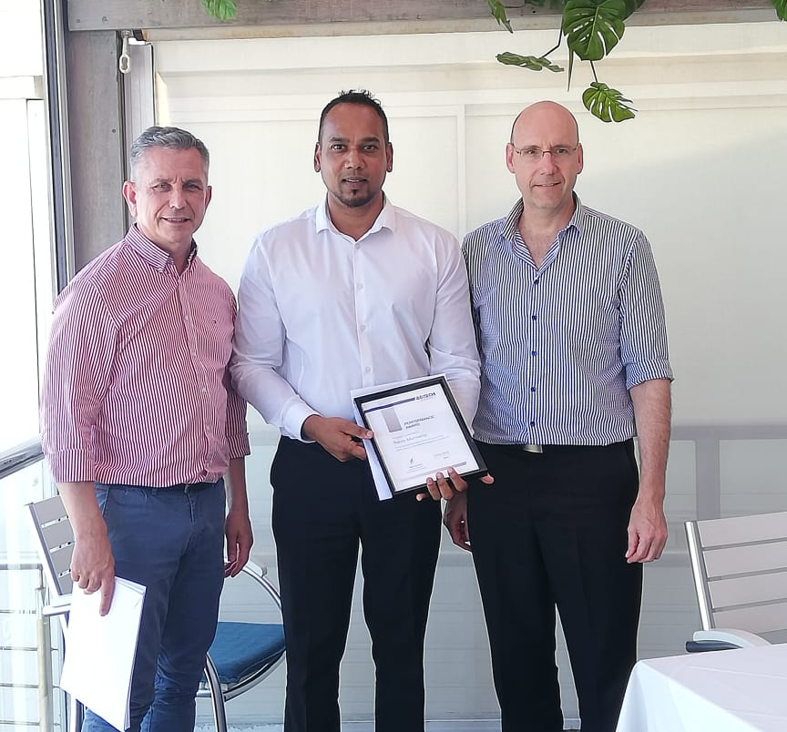 Three men standing next to each other holding a certificate