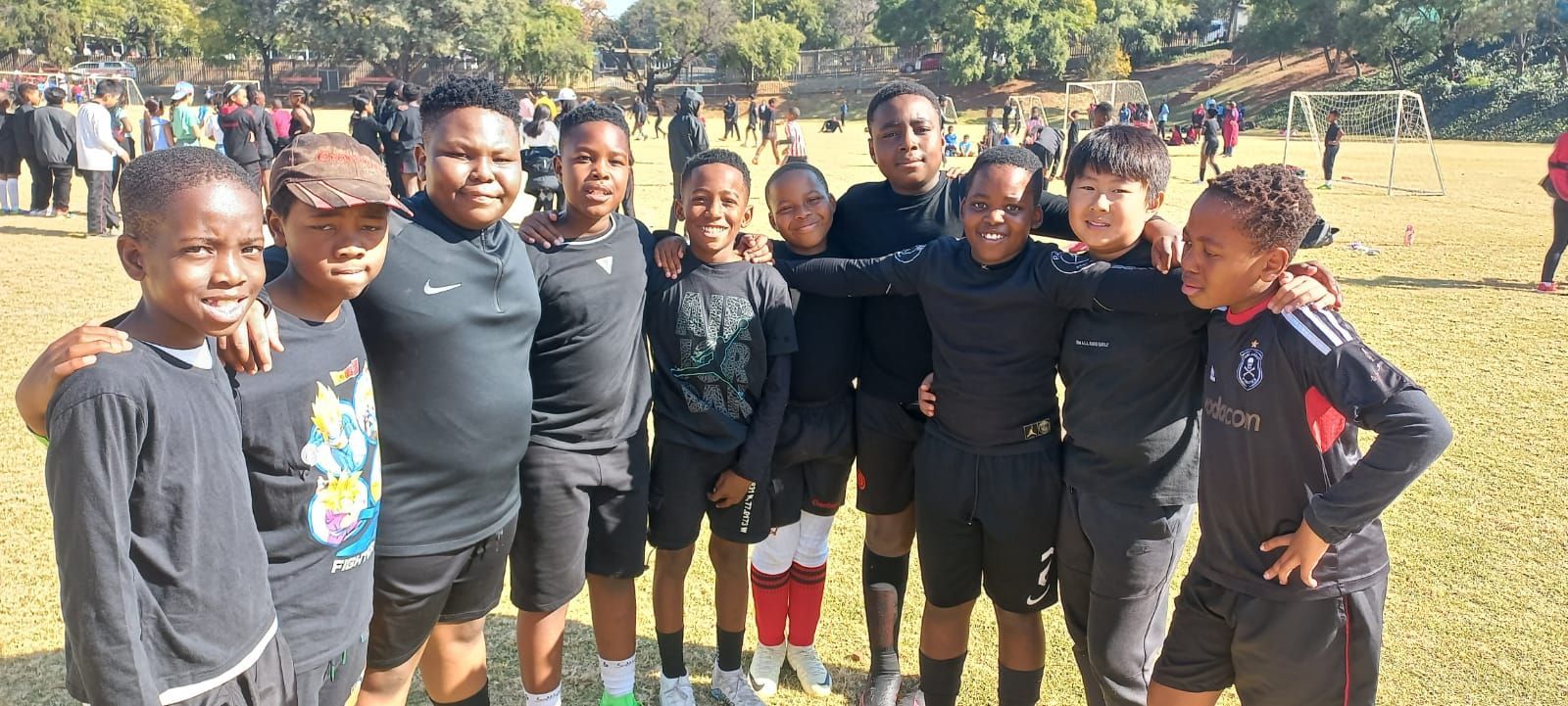 A group of young boys are posing for a picture on a field.