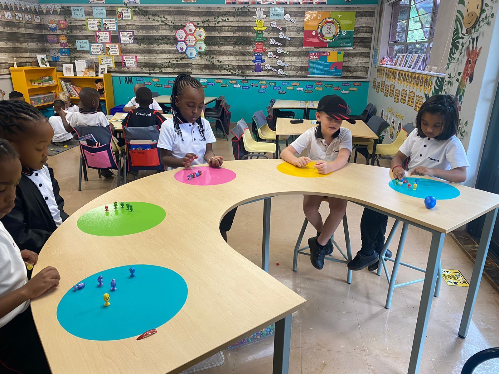 A group of children are sitting at tables in a classroom.