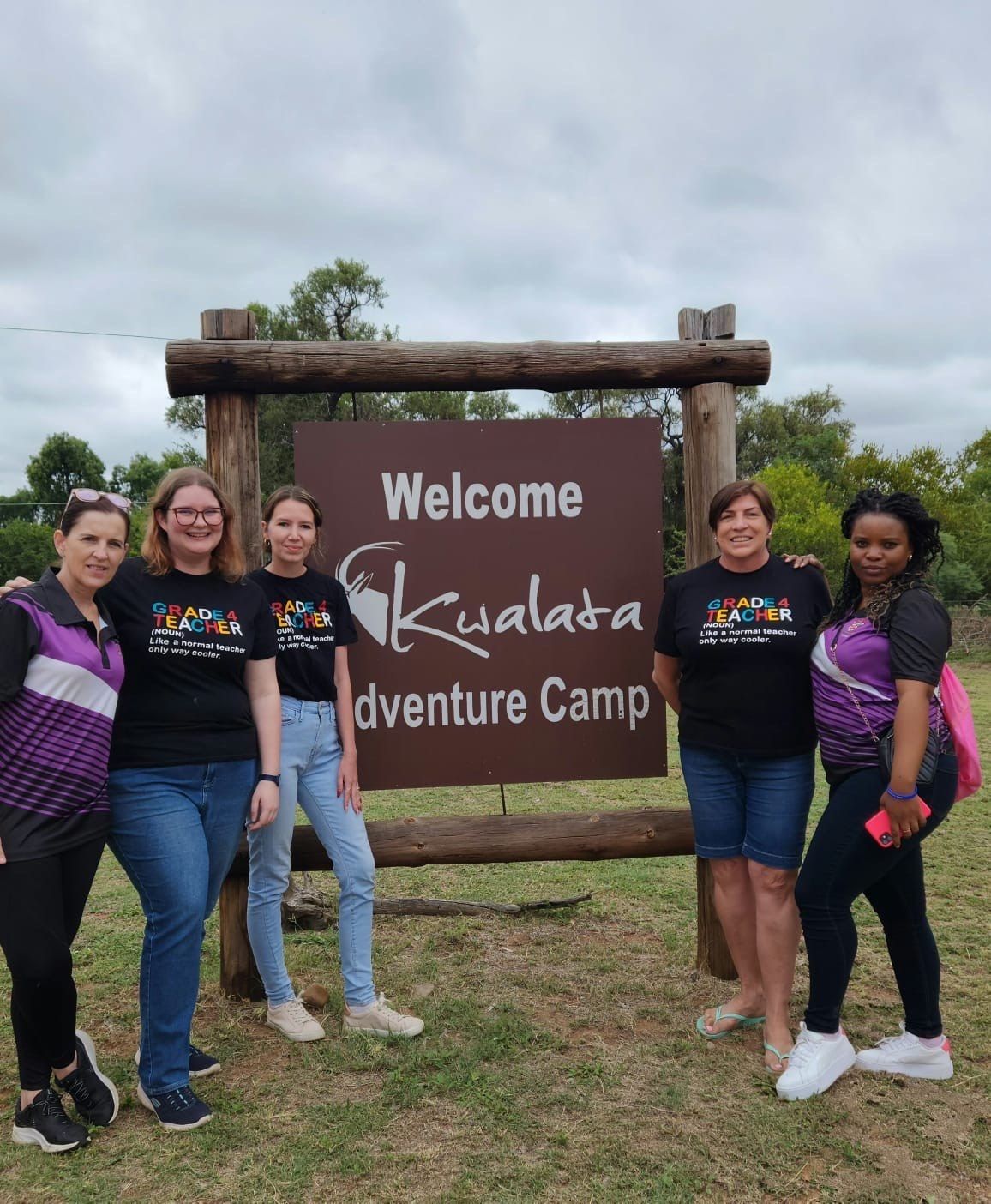 A group of women standing in front of a welcome sign
