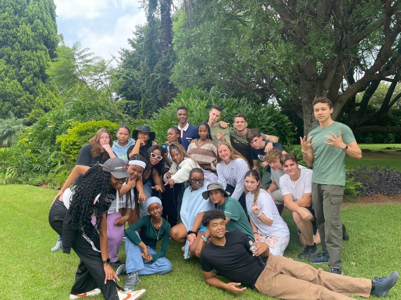 A group of people are posing for a picture in a park.