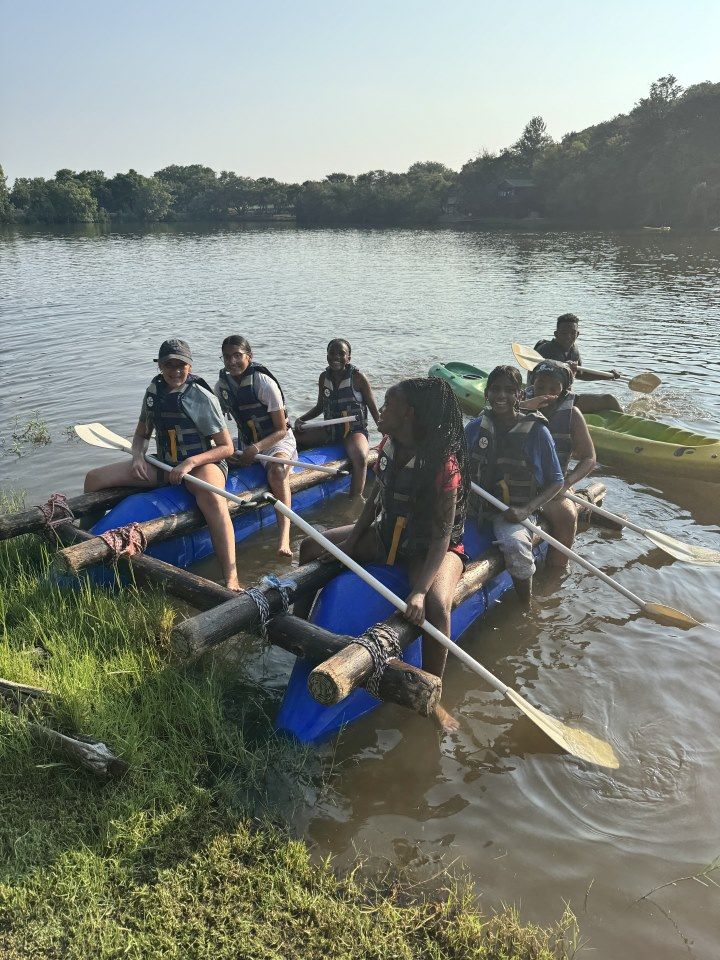 A group of people are sitting on a raft in the water.