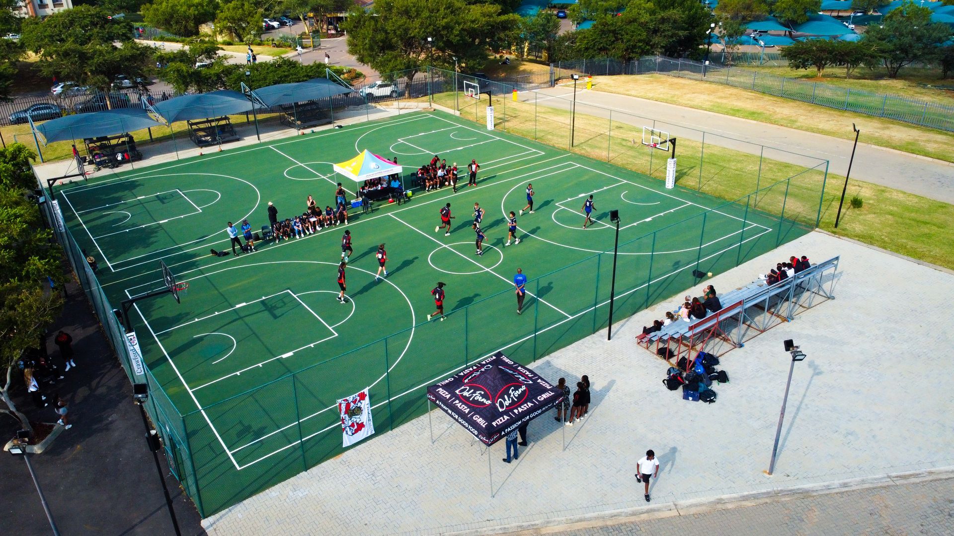 An aerial view of a basketball court with people playing basketball.