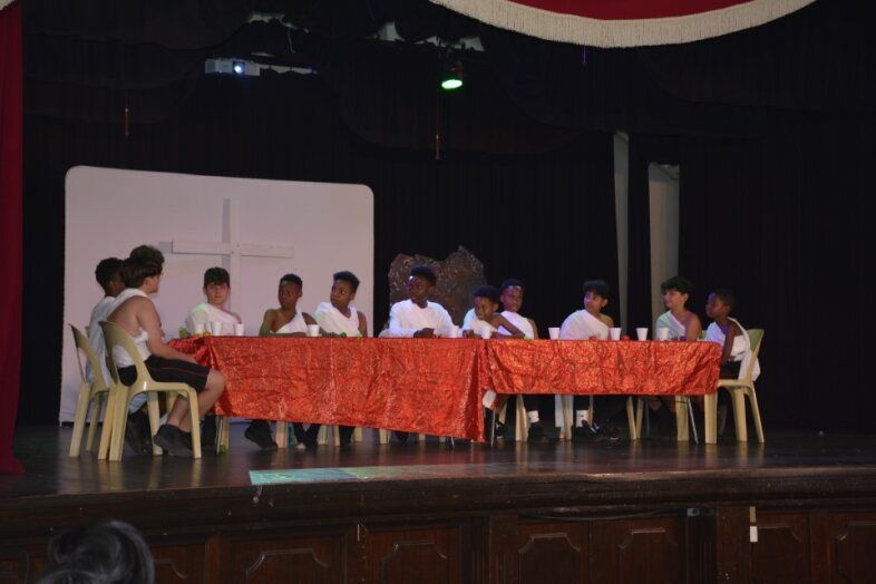 A group of people sitting around a table on a stage