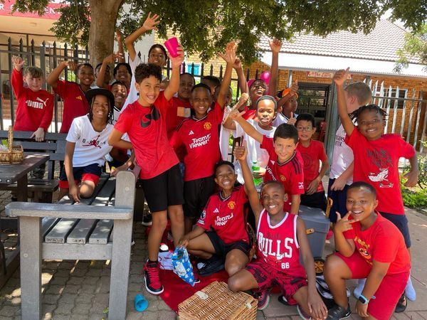 A group of children are posing for a picture with one wearing a bulls jersey