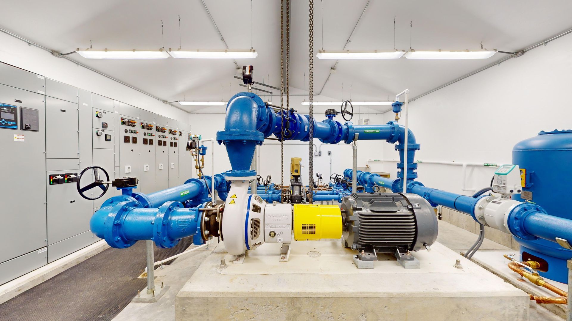 A room filled with lots of blue pipes and a motor.