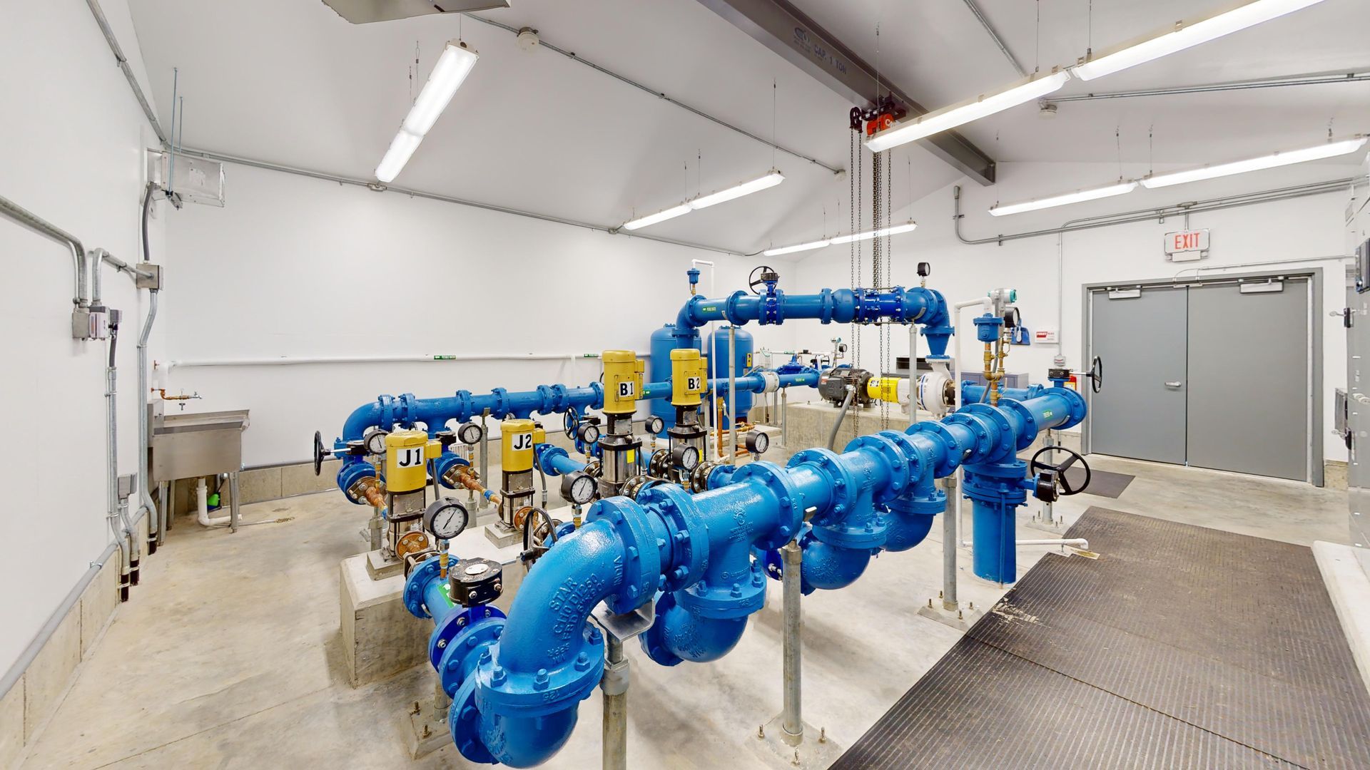 A room filled with lots of blue pipes and pumps.
