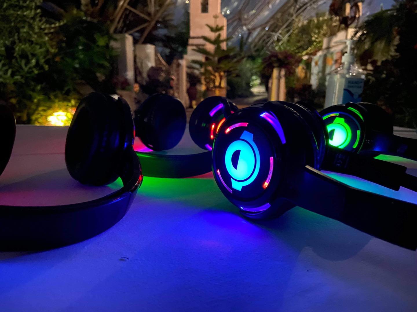 Headphones with colorful LED lights on a table at night.