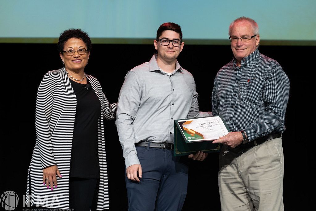 Man receiving award from two people on a stage.