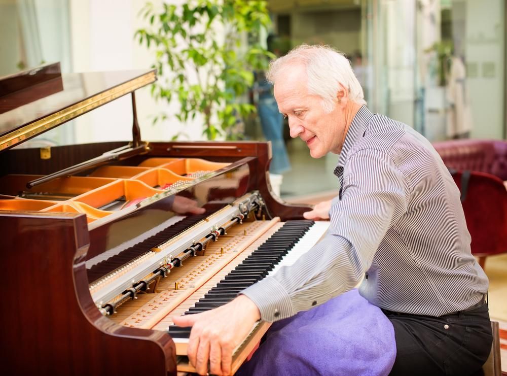 A Man Is Sitting at A Piano Playing a Song — David Simpson Pty Ltd in Redlynch, QLD
