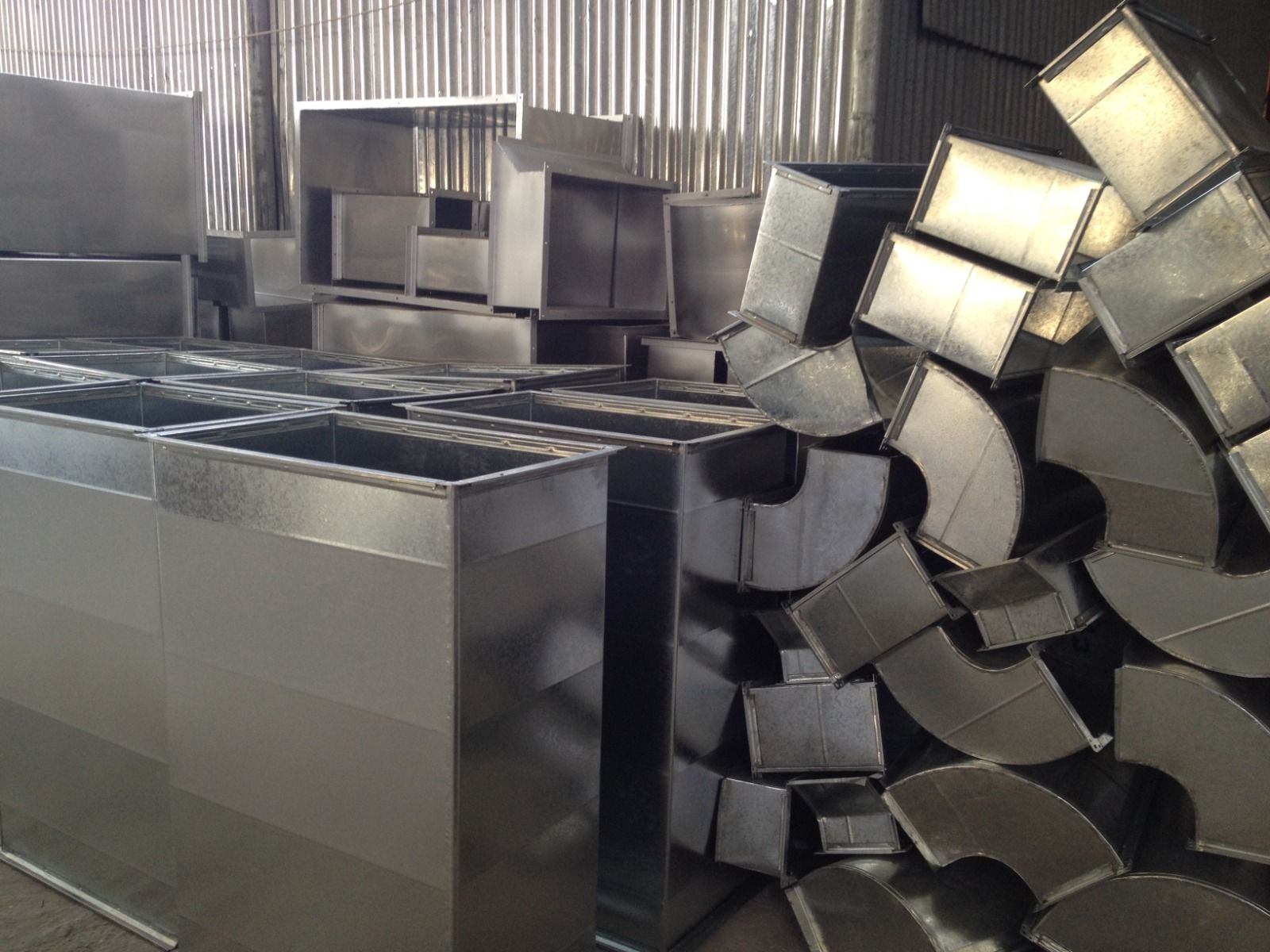 A bunch of stainless steel pipes are stacked on top of each other