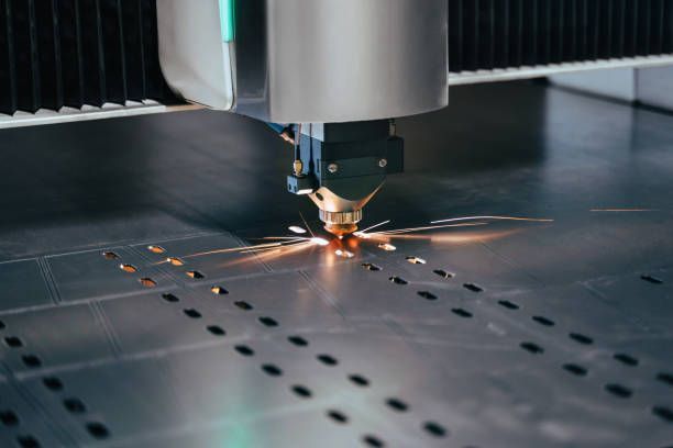 A machine is cutting a piece of metal with sparks coming out of it.