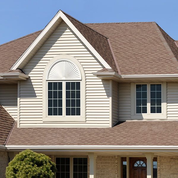 Suburban beige house exterior with gabled roof and front windows