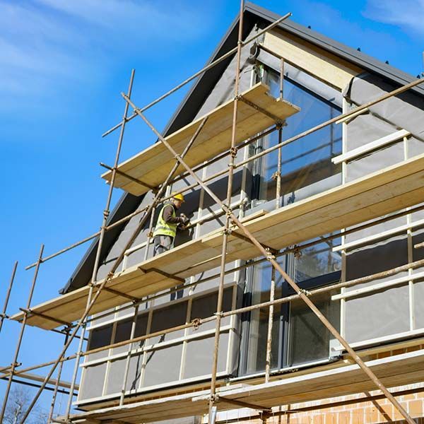 Construction workers on scaffolding outside a building under renovation
