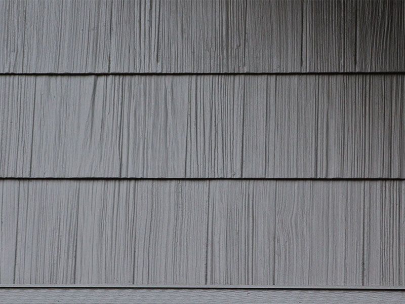 Gray horizontal siding with a wood-grain texture and dark seams between panels