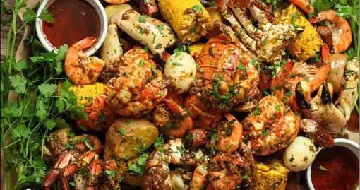 A seafood boil platter with crab, lobster, shrimp, potatoes, and corn on the cob