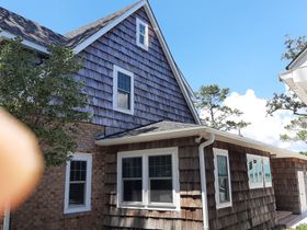 House under construction with exposed wooden framing and two ladders.