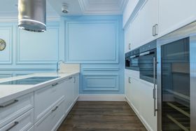 Kitchen with wood cabinets, island with wine rack, granite countertops, and stainless steel appliances.