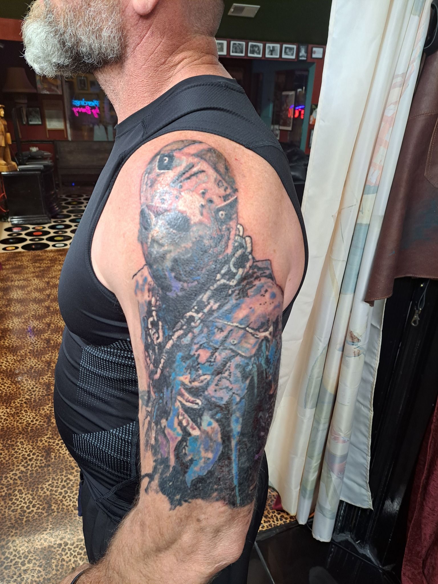 Man with Jason Voorhees tattoo on arm. Tattoo is detailed, colored, and large.
