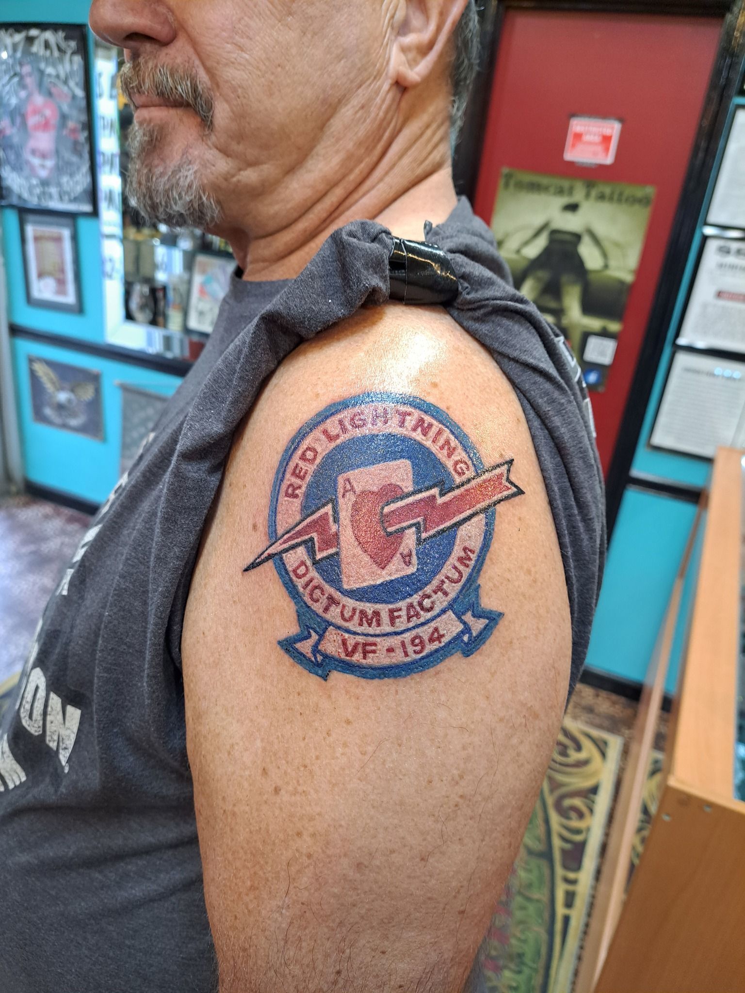 Man with a shoulder tattoo of a navy insignia, 