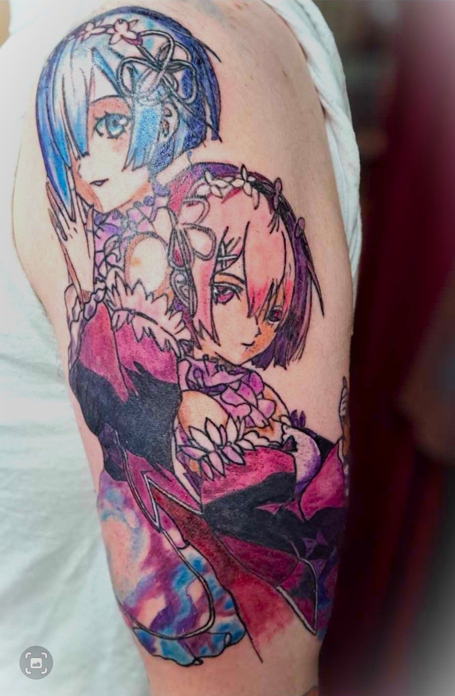 Tattoo of anime characters Rem and Ram from Re:Zero on a person's upper arm; blue and pink hair.