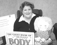 Woman holding a large book titled