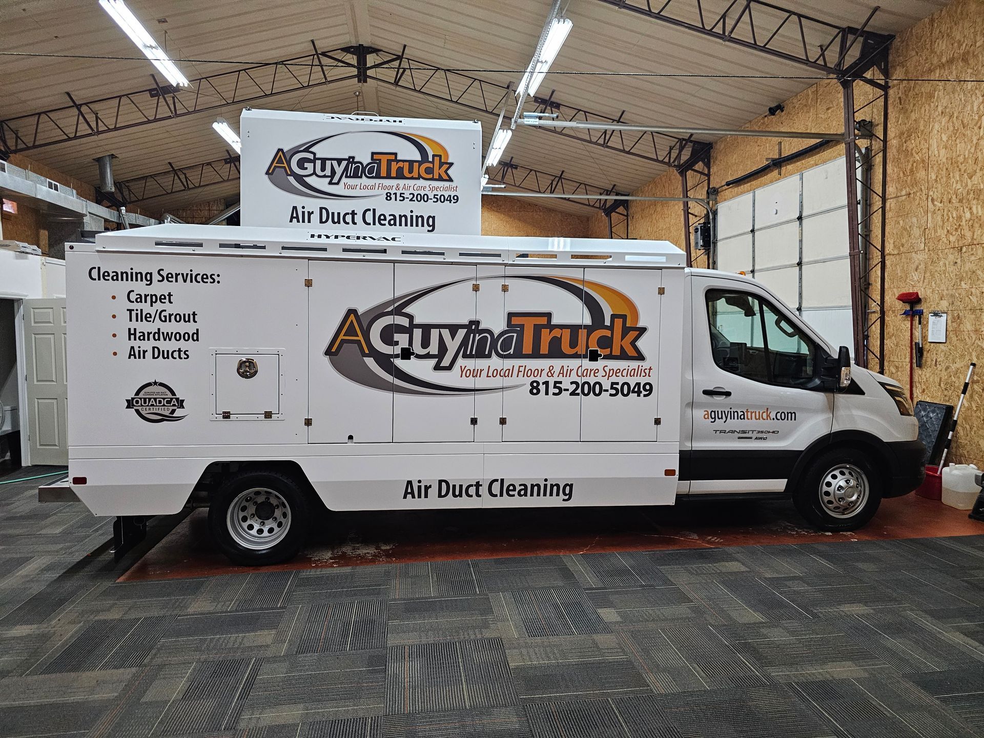 A Guy in a Truck air duct cleaning vehicle inside a service garage in Fox Valley.