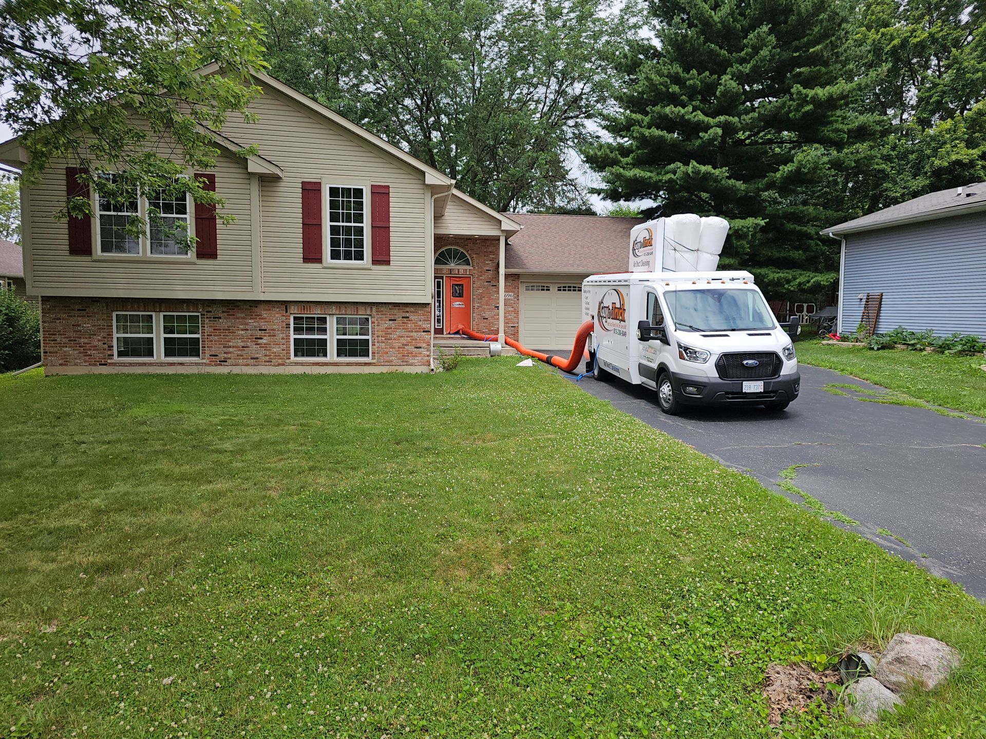 A Guy in a Truck air duct cleaning vehicle parked in a driveway while servicing a residential home.