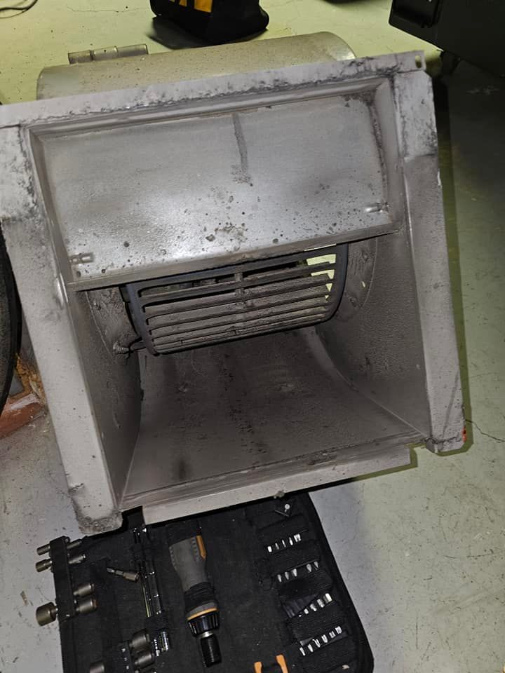 Dirty furnace blower assembly removed for cleaning, with tools laid out beside it.