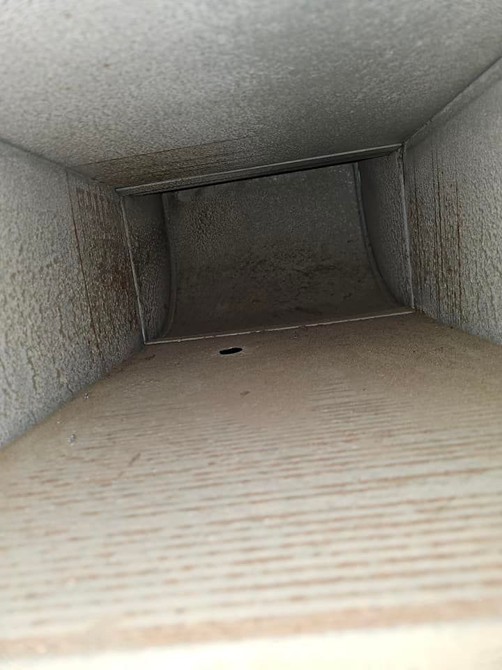 Clean air duct interior after vacuuming, with clear metal surfaces and minimal remaining residue.