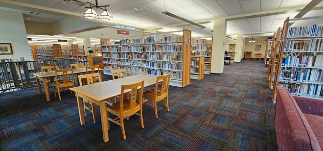 Clean library interior with carpeted floors, bookshelves, and reading tables after professional commercial carpet cleaning