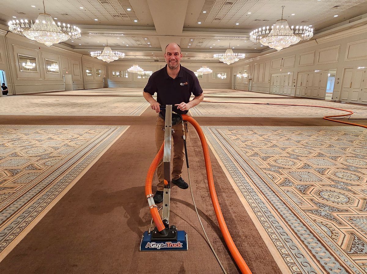 Technician cleaning large commercial banquet hall carpet with A Guy in a Truck professional carpet cleaning equipment