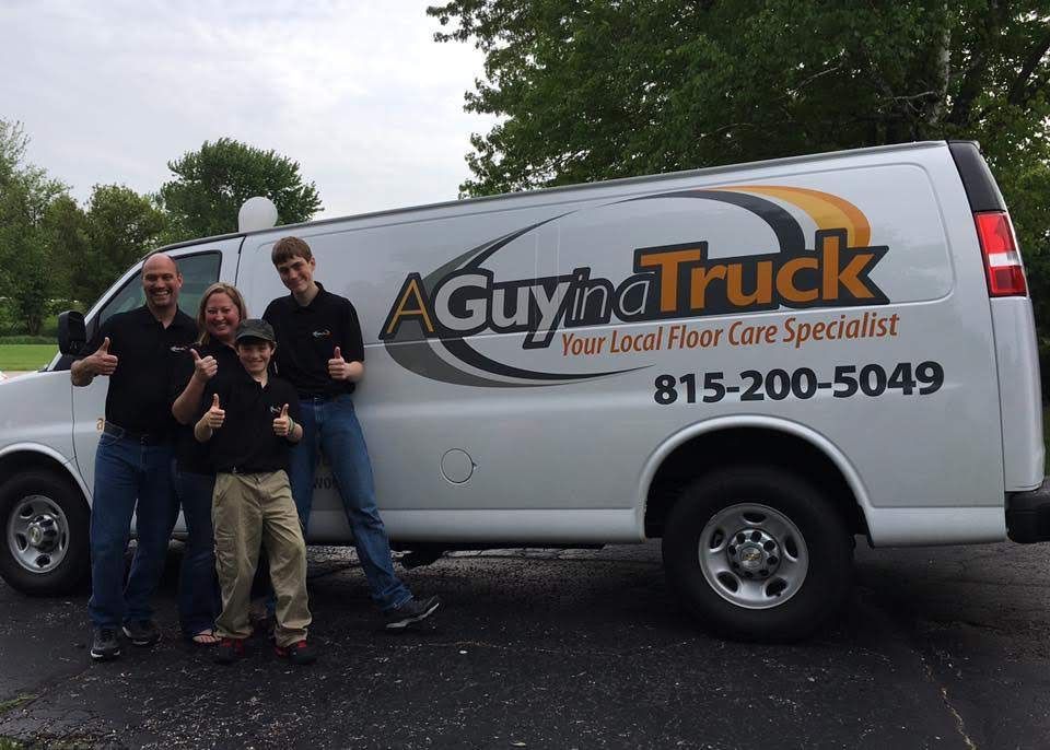 A group of four people giving thumbs-up gestures in front of a white van branded 