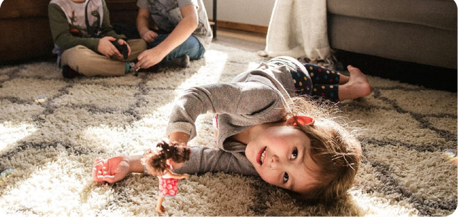Children playing on clean, soft carpet in a living room after professional residential carpet cleaning
