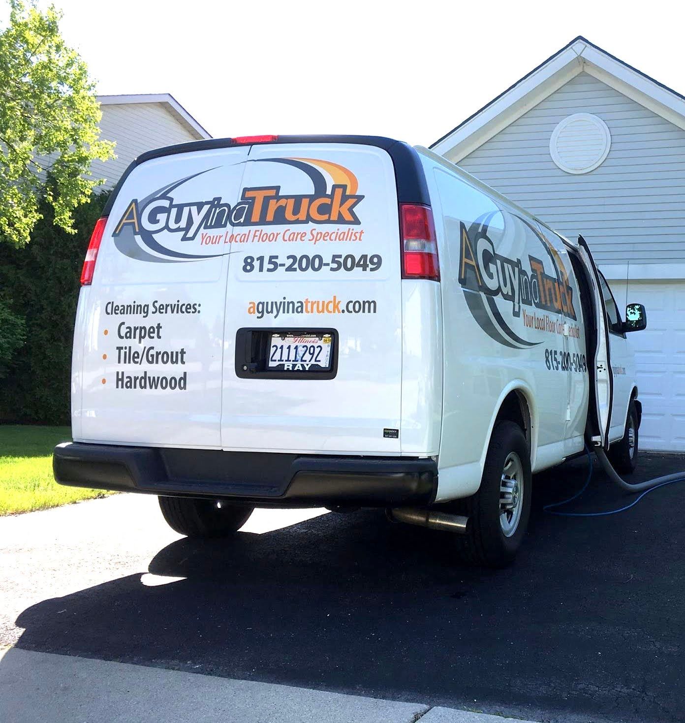 A white A Guy in a Truck service van parked in a driveway, advertising carpet, tile, and hardwood floor cleaning.