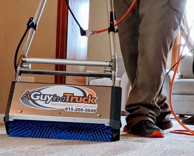 Technician cleaning carpet with professional equipment from A Guy in a Truck inside a home