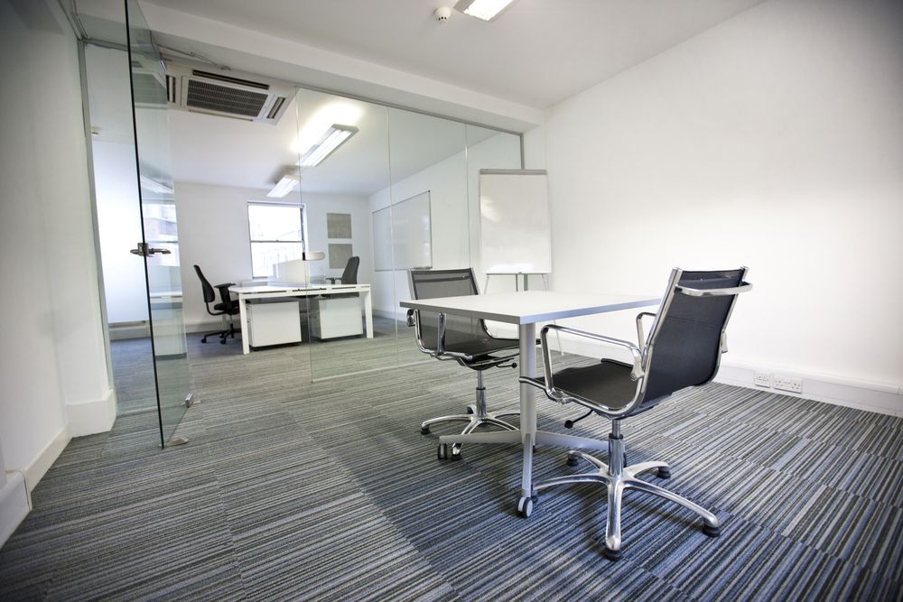 Clean commercial office space with carpeted flooring and conference seating after professional carpet cleaning