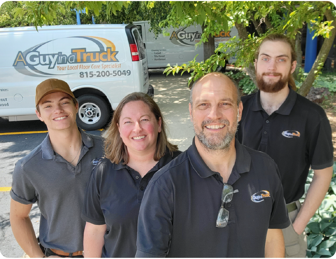 A Guy in a Truck family picture smiling together in branded shirts with company service van in background