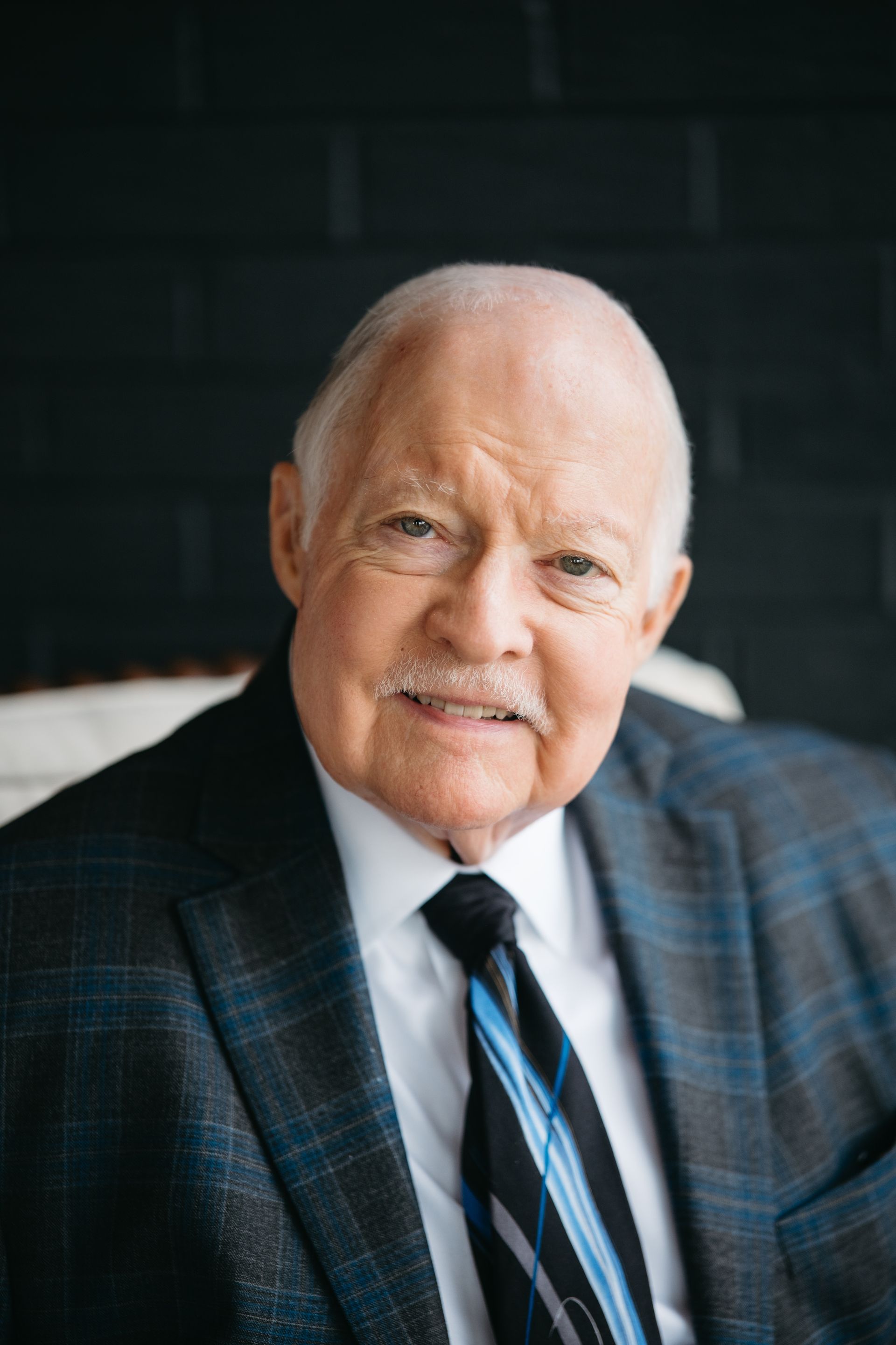 Frank Taylor headshot. A man wearing a dark colored suit and tie.