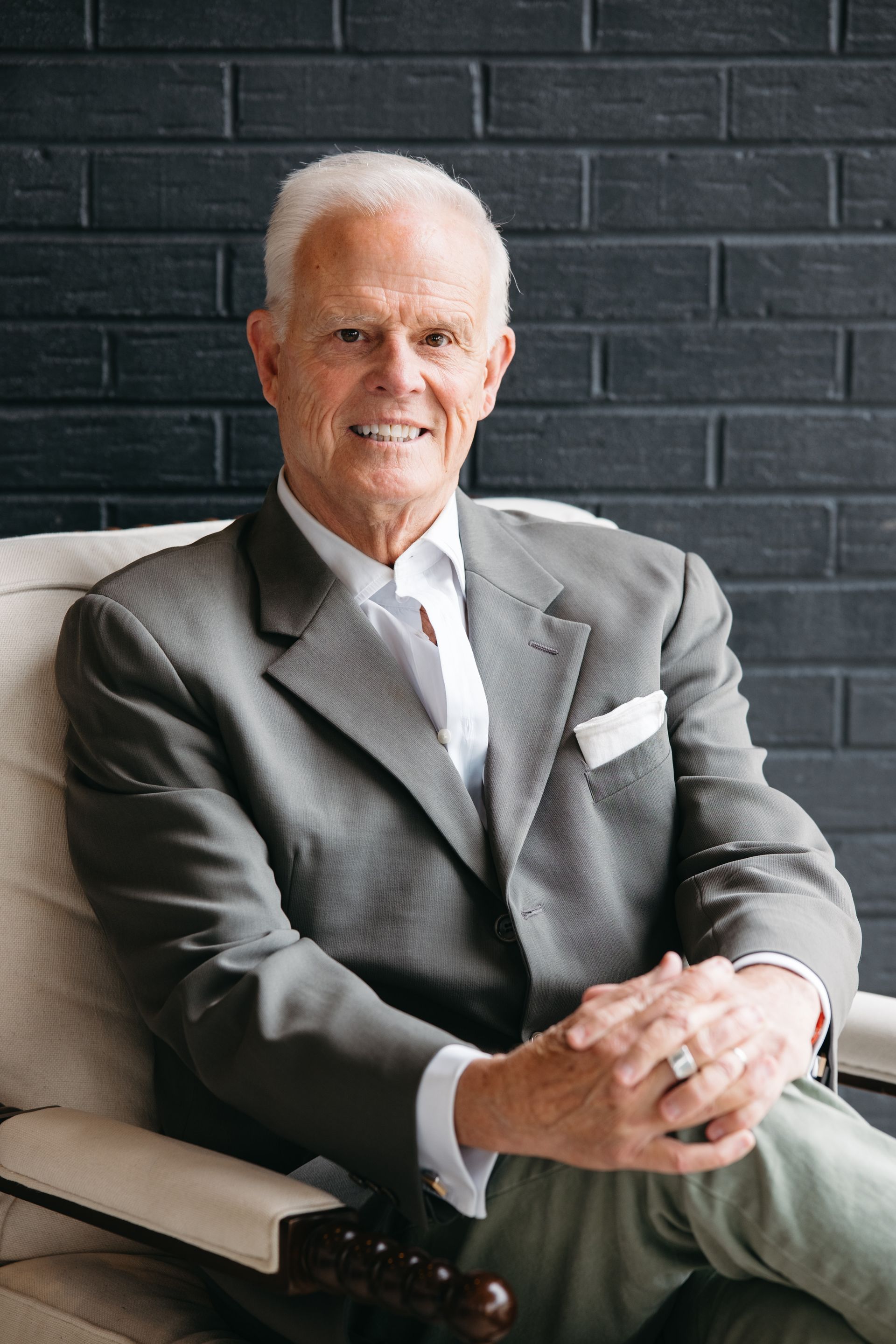 Smiling man in a gray suit.