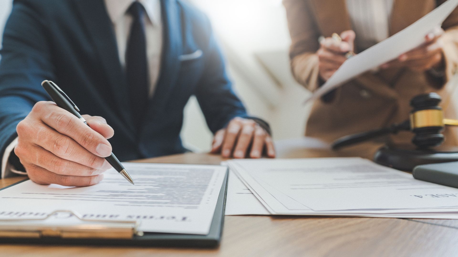 two people reviewing and signing documents