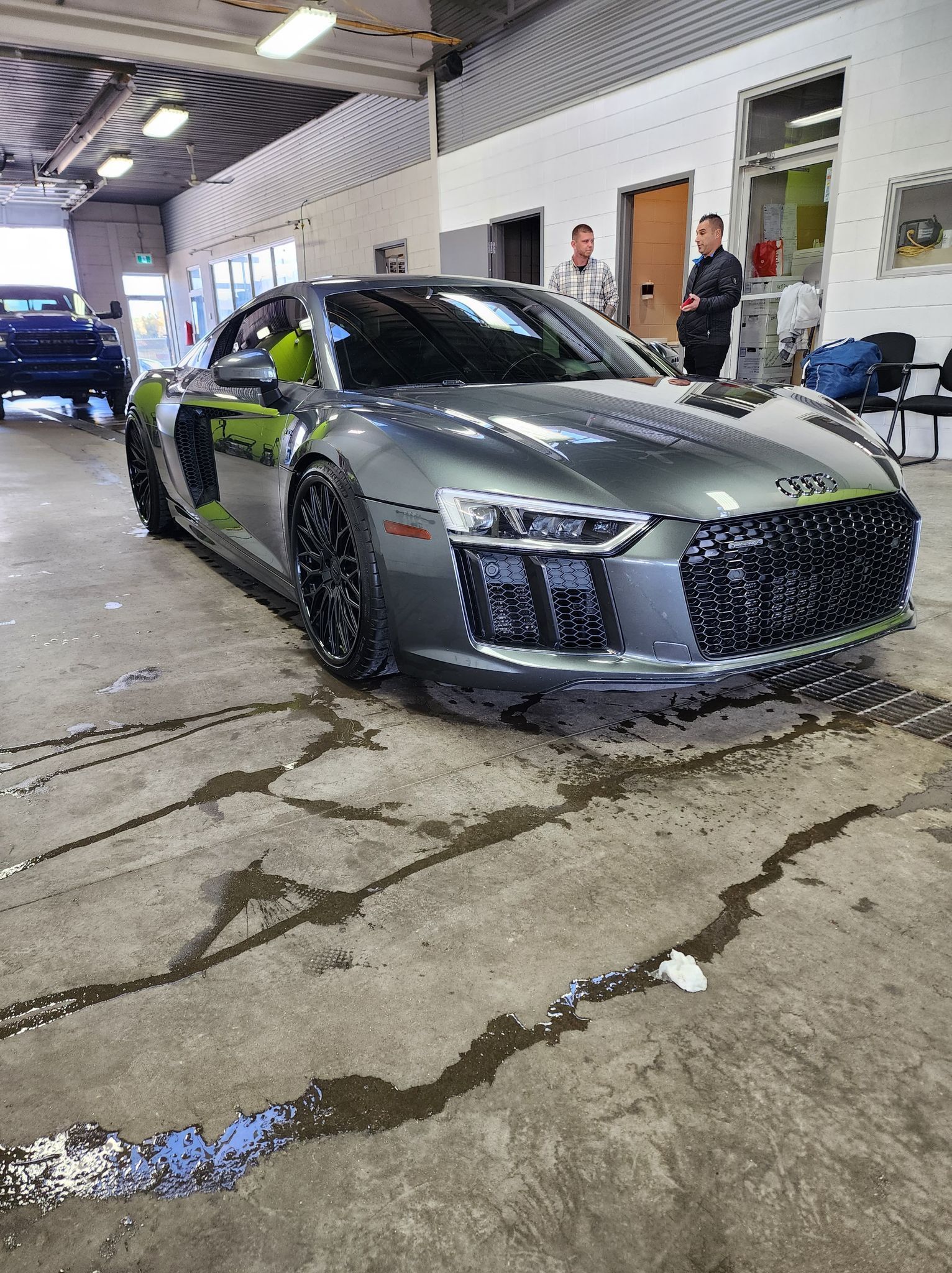 A gray audi r8 is parked in a garage.