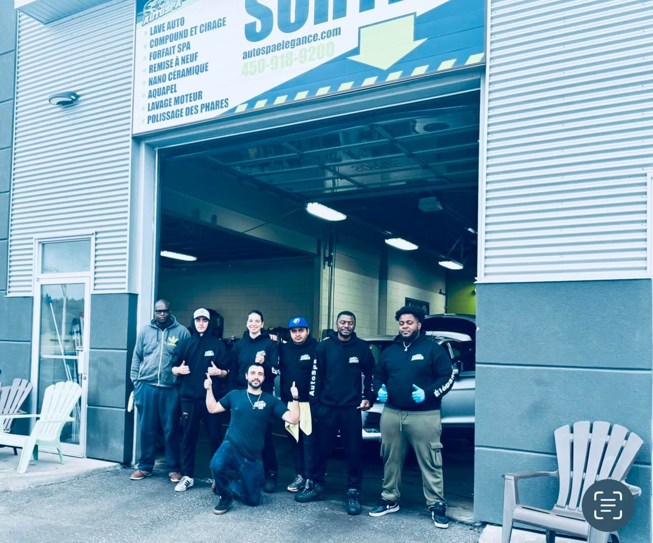 A group of men are posing for a picture in front of a garage door.